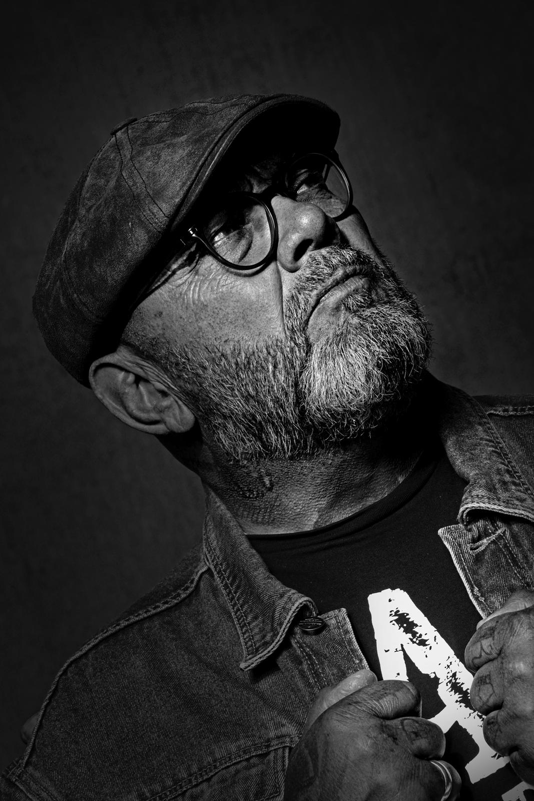 Zwart-wit portret van Henk Kuipers met pet en bril