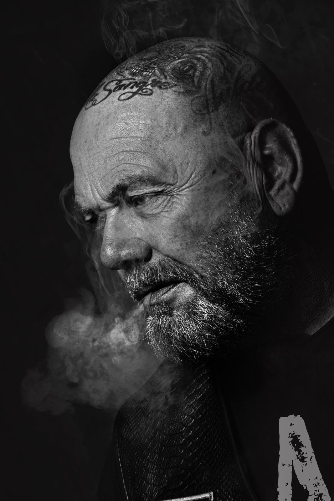 Zwart-wit sfeerportret van Henk Kuipers met rook
