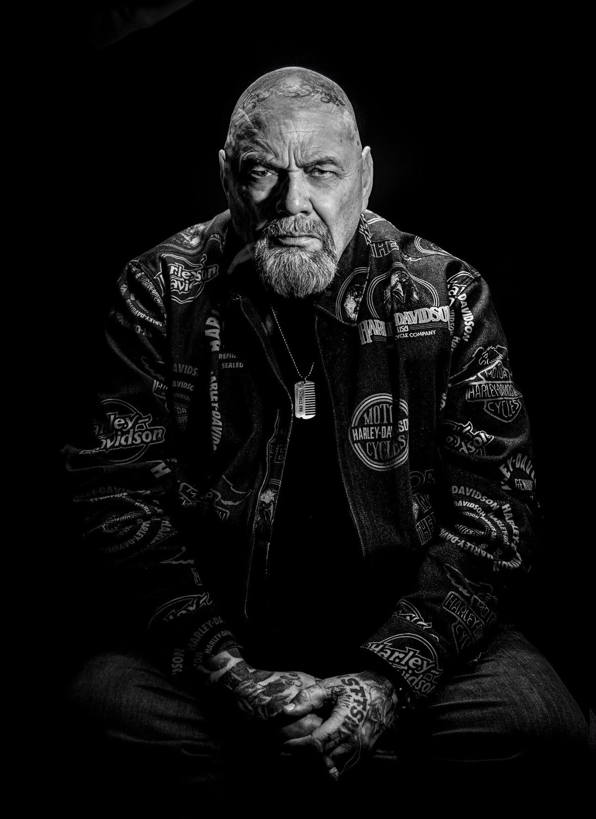 Zwart-wit portret van Henk Kuipers zittend in Harley-Davidson jack